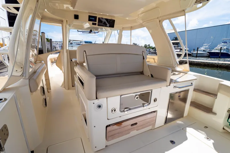 Slide: The Image of 2019 Boston Whaler 350 Realm interior with seating and storage, docked at marina. - 97