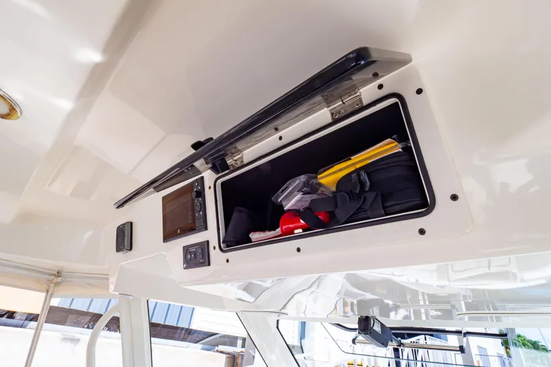 Slide: The Image of Storage compartment on a 2019 Boston Whaler 350 Realm boat, containing safety equipment. - 99