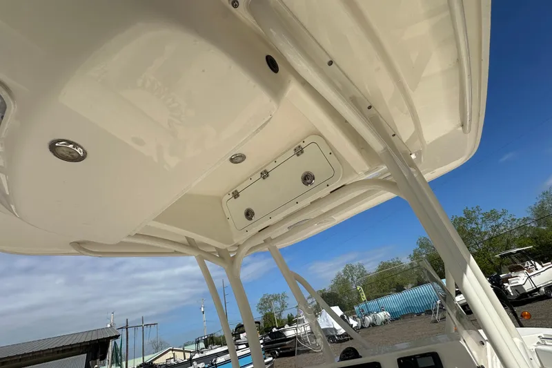 Slide: The Image of 2022 Cobia 220 Center Console boat's overhead view with storage compartment and clear sky. - 13