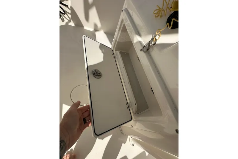 Slide: The Image of Open storage compartment on 2022 Cobia 220 Center Console boat. - 15