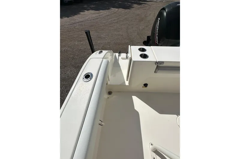 Slide: The Image of 2022 Cobia 220 Center Console boat interior with rod holders and Mercury engine. - 17