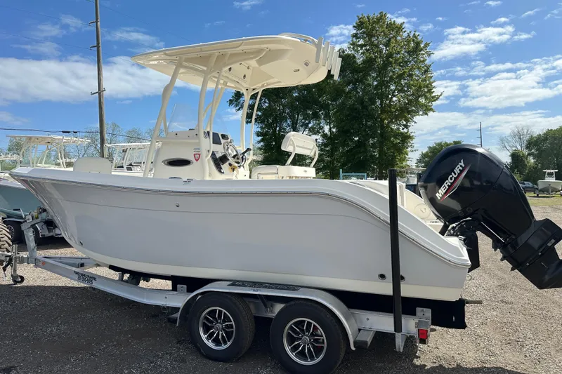 Slide: The Image of 2022 Cobia 220 Center Console boat on trailer with Mercury outboard motor. - 2