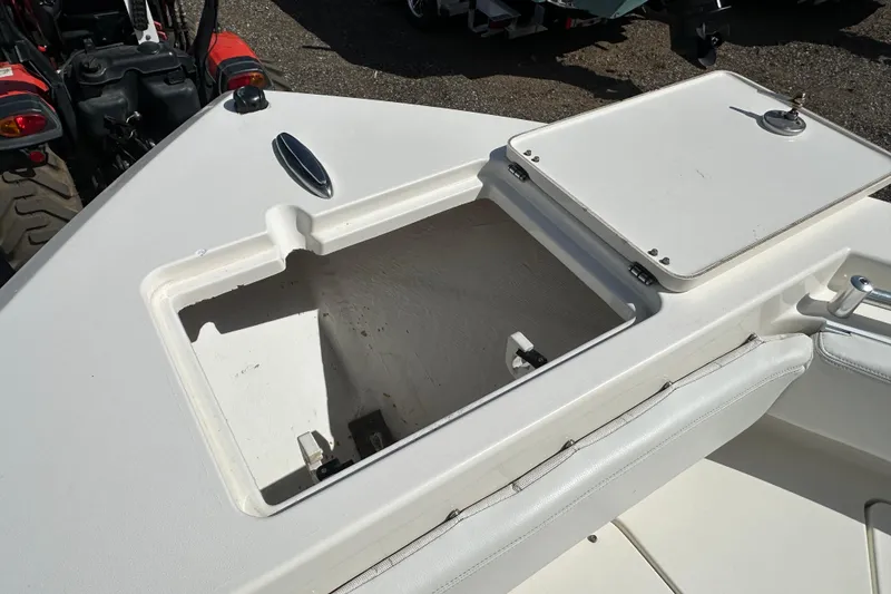 Slide: The Image of 2022 Cobia 220 Center Console boat storage compartment open, showcasing interior space. - 22