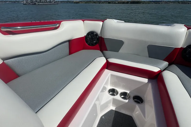 Slide: The Image of Interior of 2017 Moomba Helix boat with red and gray seating on a lake. - 10