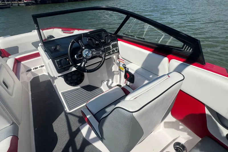 Slide: The Image of 2017 Moomba Helix boat interior with steering wheel and red accents on water. - 14