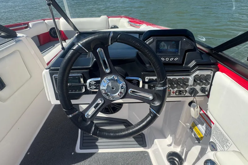 Slide: The Image of 2017 Moomba Helix boat dashboard with steering wheel and control panel. - 15