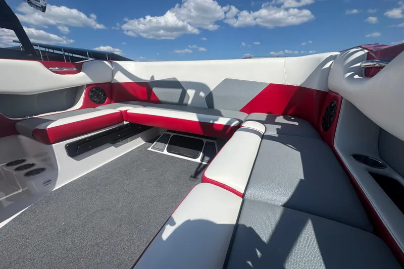 Slide: The Image of 2017 Moomba Helix boat interior with red and gray seating under a blue sky. - 21