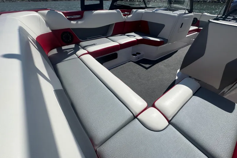 Slide: The Image of 2017 Moomba Helix boat interior with red and gray seating, on a sunny day. - 22