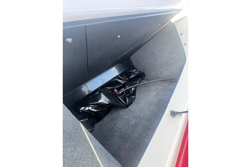 Slide: The Image of 2017 Moomba Helix boat storage compartment with black bag and hose. - 28