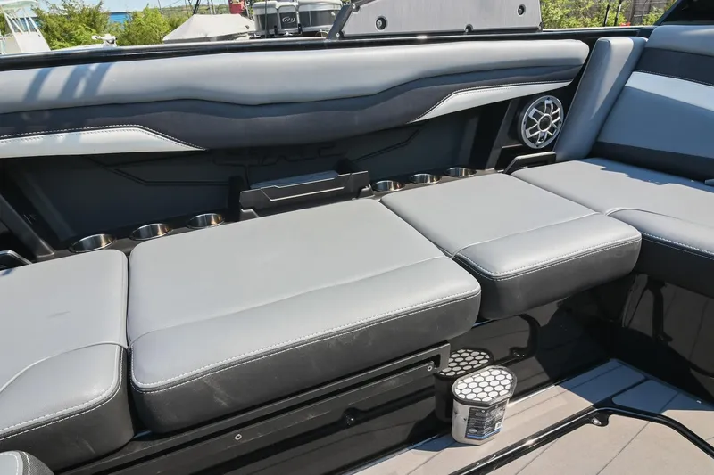 Slide: The Image of 2023 Axis T220 boat interior with gray seating, cup holders, and speaker. - 27