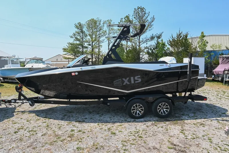 Slide: The Image of 2023 Axis T220 boat on trailer, parked outdoors, showcasing sleek black design. - 3