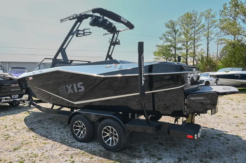 Slide: The Image of 2023 Axis T220 boat on trailer, sleek black design, parked outdoors. - 4