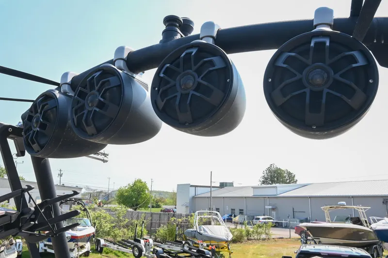 Slide: The Image of Four black speakers mounted on a 2023 Axis T220 boat, with a marina background. - 44