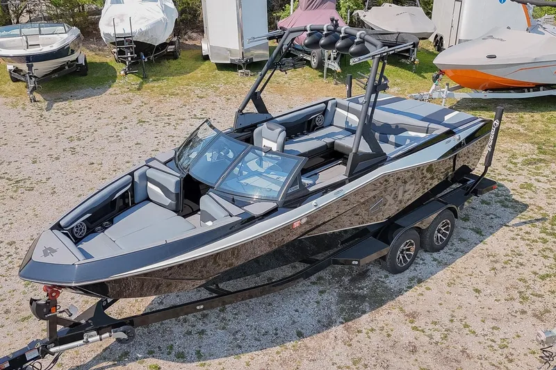 Slide: The Image of 2023 Axis T220 boat on trailer, sleek design, parked outdoors among other boats. - 50