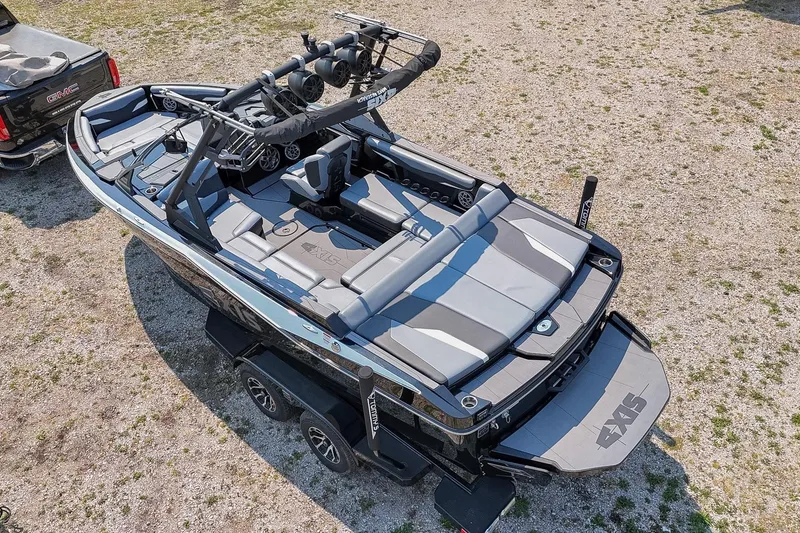 Slide: The Image of 2023 Axis T220 boat on trailer, sleek design, parked beside a GMC truck. - 52