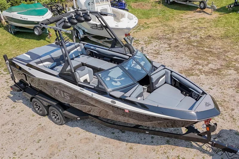 Slide: The Image of 2023 Axis T220 boat on trailer, sleek design, black and gray color scheme, outdoor setting. - 56