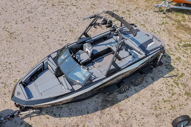 Slide: The Image of 2023 Axis T220 boat on trailer, aerial view, parked on gravel surface. - 57