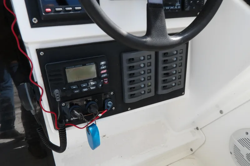 Slide: The Image of Control panel of a 1993 Wahoo 2600 boat with steering wheel and electronic equipment. - 12