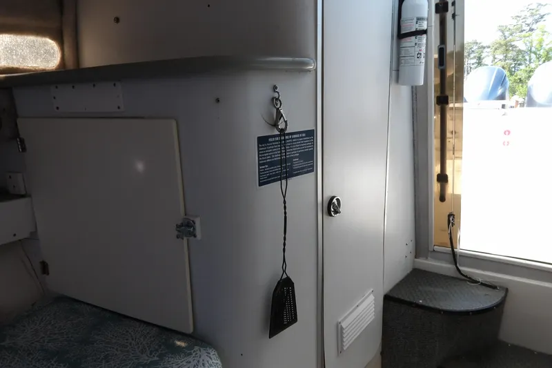 Slide: The Image of Interior of a 1993 Wahoo 2600 boat with a fire extinguisher and storage compartments. - 23