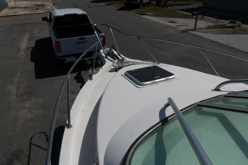 Slide: The Image of A 1993 Wahoo 2600 boat being towed by a GMC truck on a street. - 27