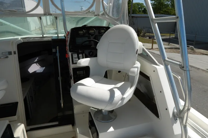 Slide: The Image of Interior of a 1993 Wahoo 2600 boat featuring a white captain's chair and control panel. - 18