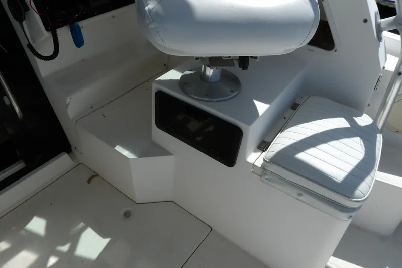 Slide: The Image of Interior of a 1993 Wahoo 2600 boat featuring white seating and storage area. - 32