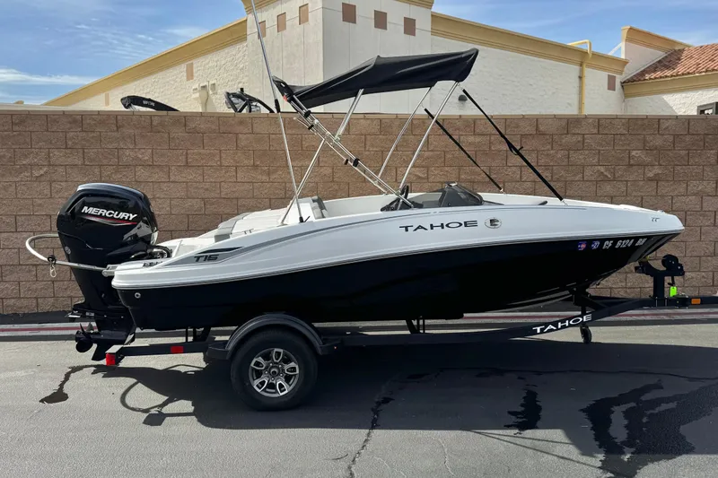 The Image of 2025 Tahoe T16 boat with Mercury engine on trailer, parked outdoors. - 0