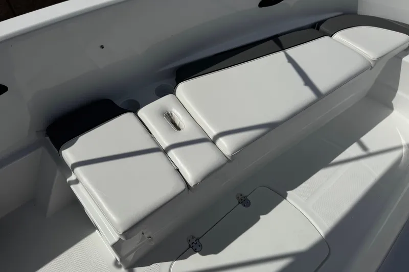 Slide: The Image of 2025 Tahoe T16 boat interior with white cushioned seating and storage compartments. - 17