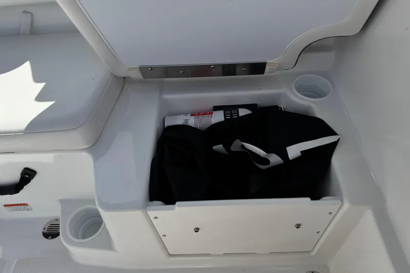 Slide: The Image of Storage compartment in a 2025 Tahoe T16 boat, featuring cup holders and safety equipment. - 20