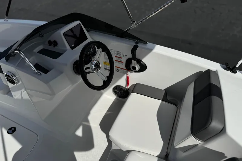 Slide: The Image of 2025 Tahoe T16 boat cockpit with steering wheel, modern controls, and comfortable seating. - 24