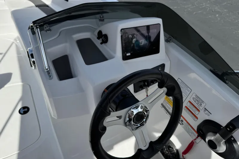 Slide: The Image of 2025 Tahoe T16 boat dashboard with steering wheel and control panel. - 26