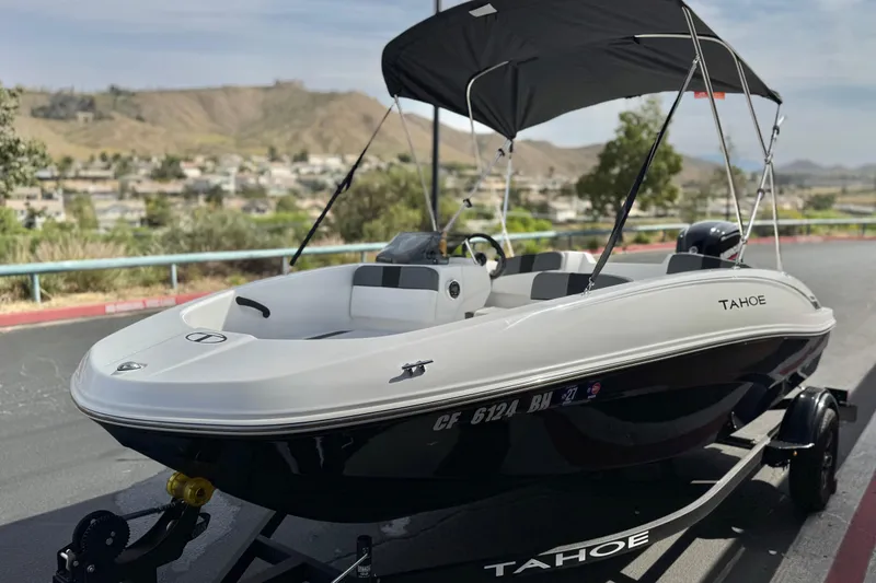 Slide: The Image of 2025 Tahoe T16 boat with canopy on trailer, scenic background. - 3