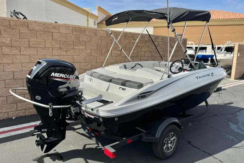 Slide: The Image of 2025 Tahoe T16 boat with Mercury engine on trailer, parked outdoors. - 5