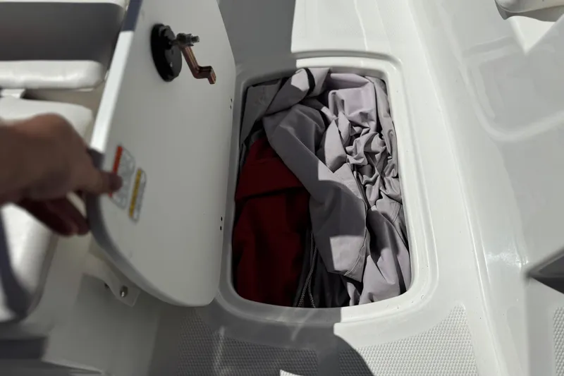Slide: The Image of Open storage compartment in 2024 Tahoe T16 boat with fabric inside. - 14
