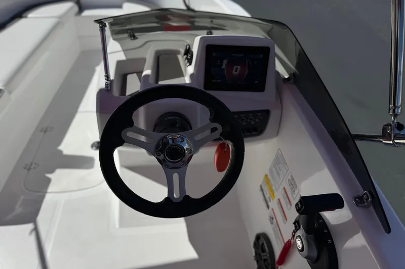 Slide: The Image of 2024 Tahoe T16 boat dashboard with steering wheel and control panel. - 24