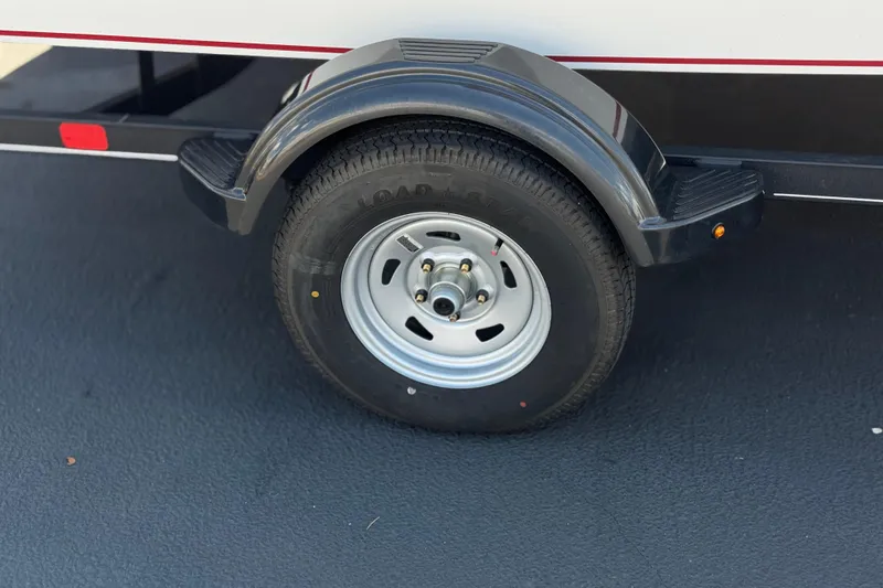 Slide: The Image of 2024 Tahoe T16 trailer wheel with black fender on asphalt surface. - 29