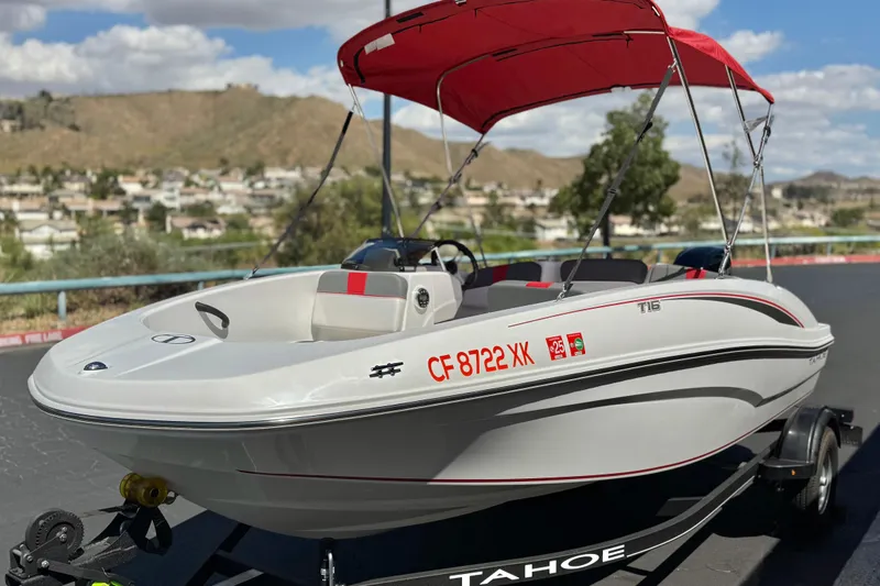 Slide: The Image of 2024 Tahoe T16 boat with red canopy on trailer, scenic background. - 3