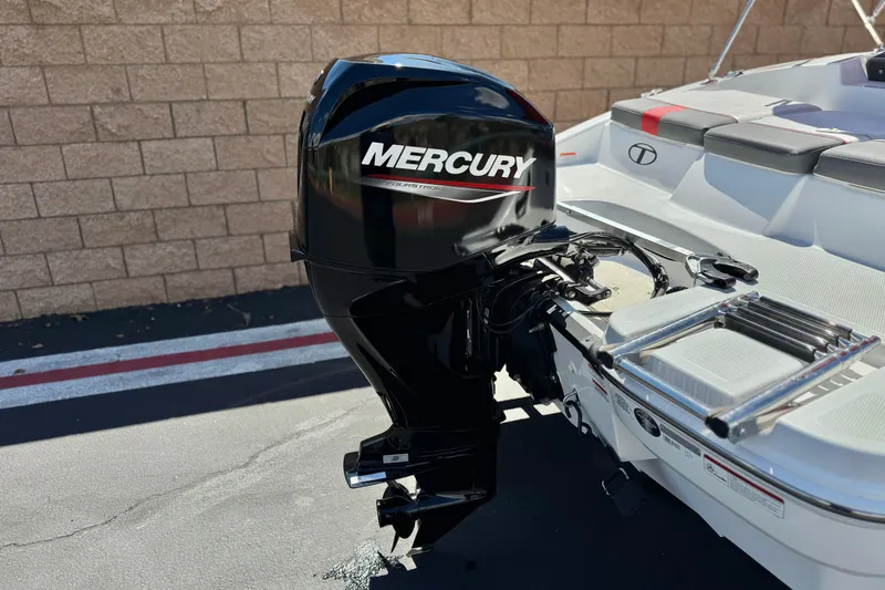 Slide: The Image of 2024 Tahoe T16 boat with Mercury outboard motor, parked near a brick wall. - 6