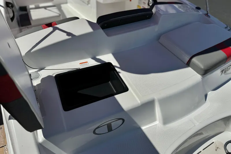 Slide: The Image of 2024 Tahoe T16 boat interior with open storage compartment and cushioned seating. - 7