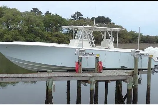 The Image of 2019 SeaVee 370Z boat docked on calm water with lush greenery background. - 1