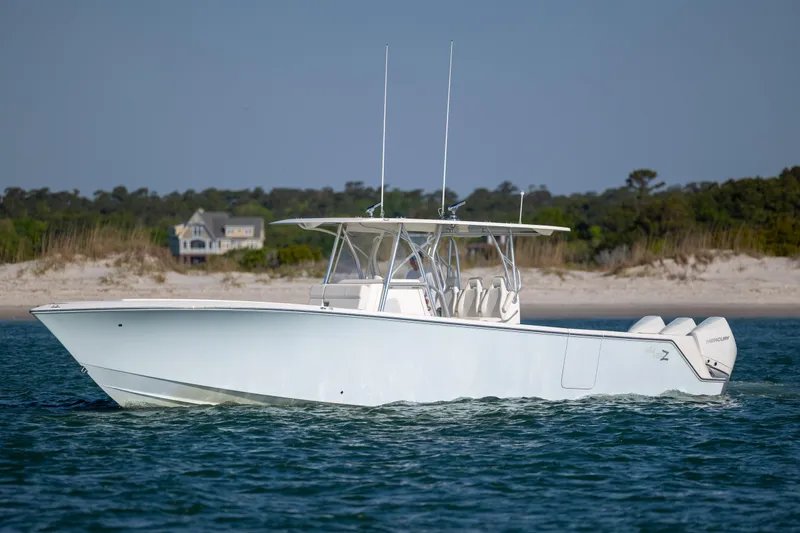 The Image of 2019 SeaVee 370Z boat cruising near a sandy shoreline with trees in the background. - 2