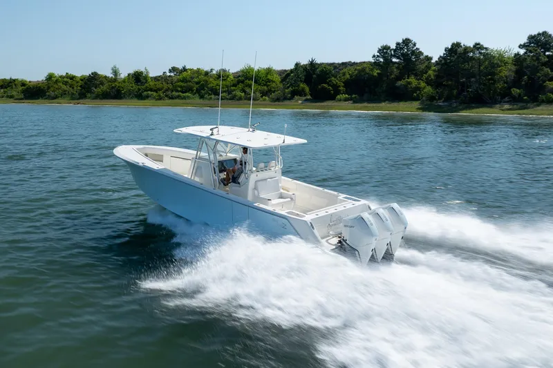 Slide: The Image of 2019 SeaVee 370Z boat cruising on water, surrounded by lush greenery. - 39