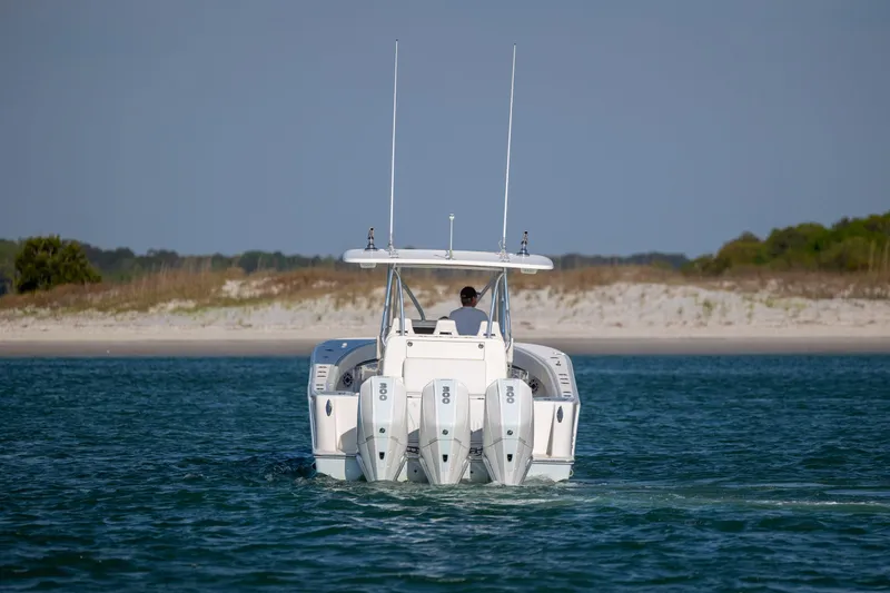 Slide: The Image of 2019 SeaVee 370Z boat cruising near a sandy shoreline. - 4