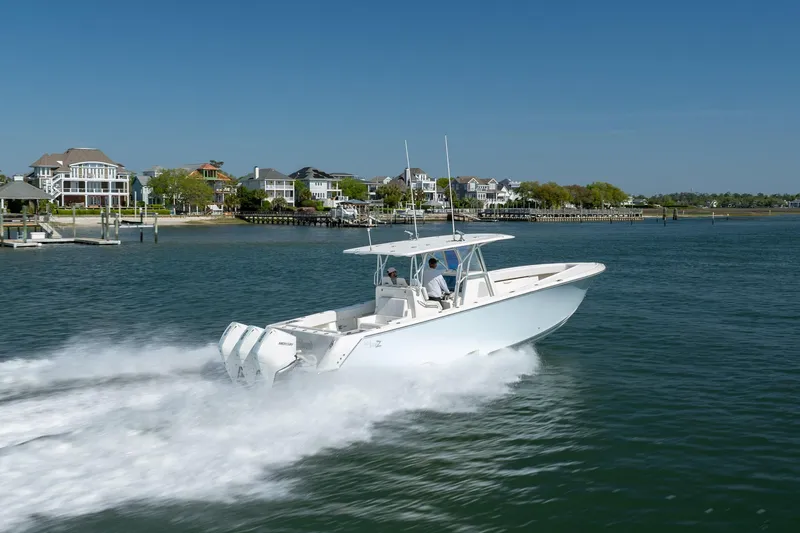 Slide: The Image of 2019 SeaVee 370Z boat cruising near waterfront homes on a sunny day. - 41