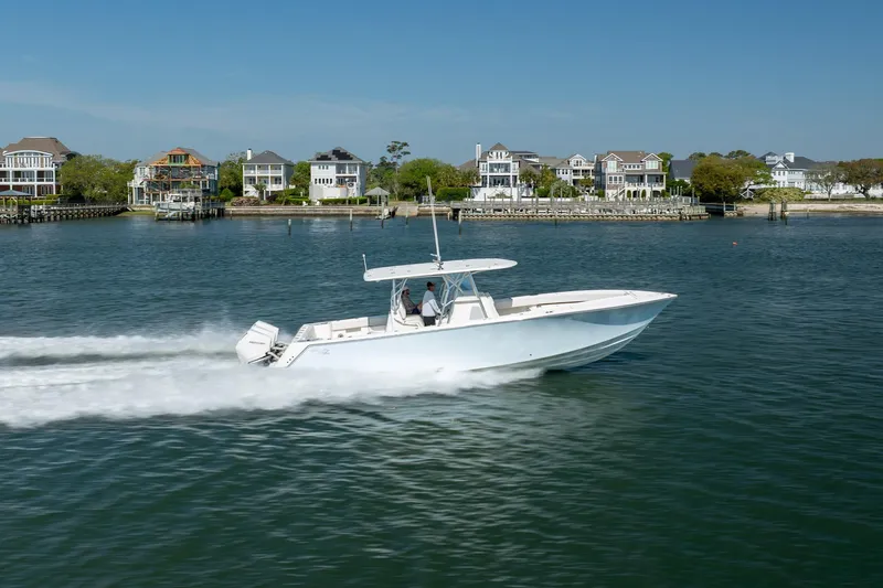 Slide: The Image of 2019 SeaVee 370Z boat cruising on water near waterfront homes. - 42