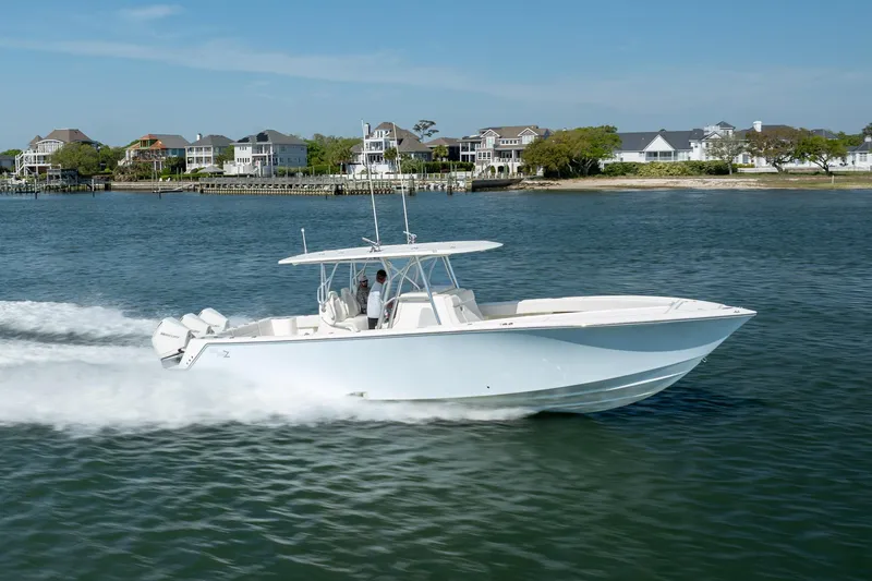 Slide: The Image of 2019 SeaVee 370Z boat cruising on water near coastal homes. - 43