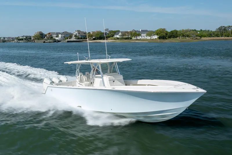 Slide: The Image of 2019 SeaVee 370Z boat cruising on water near coastal homes. - 44