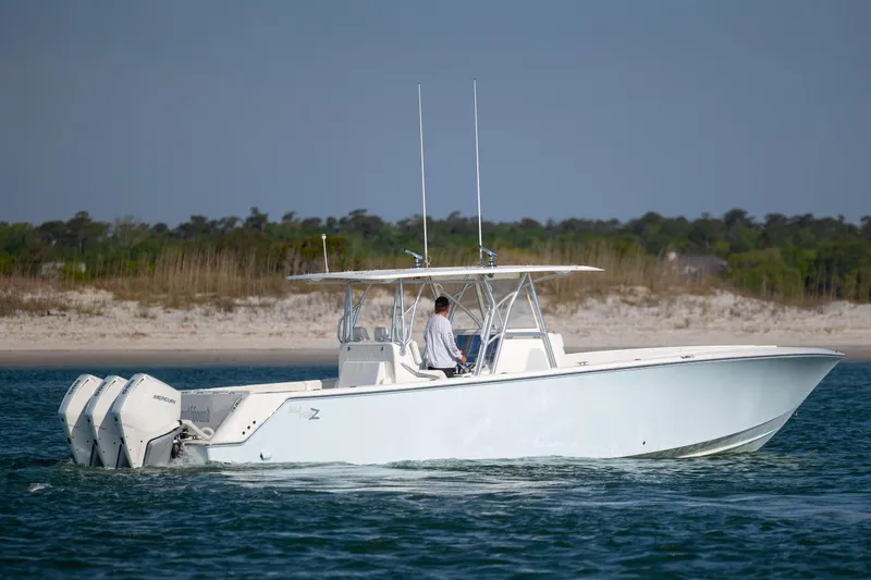 Slide: The Image of 2019 SeaVee 370Z boat cruising near a sandy shoreline. - 5