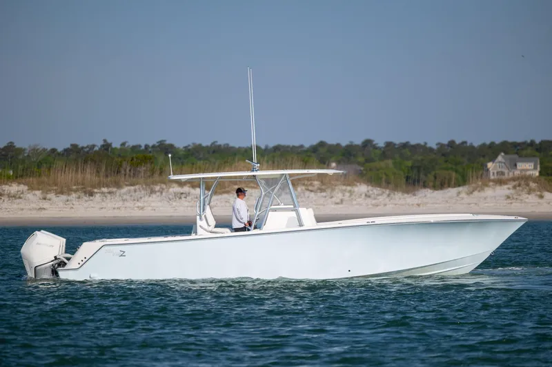 Slide: The Image of 2019 SeaVee 370Z boat cruising near a sandy shoreline. - 6