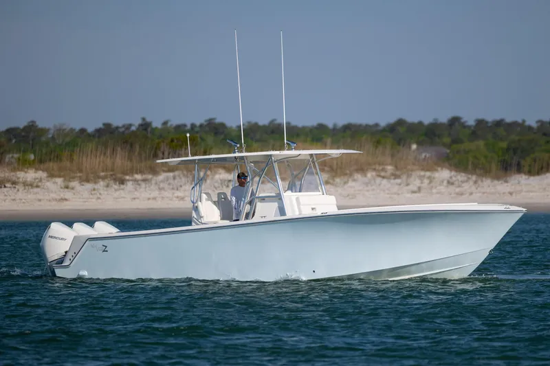 Slide: The Image of 2019 SeaVee 370Z boat cruising on water near sandy shoreline. - 7